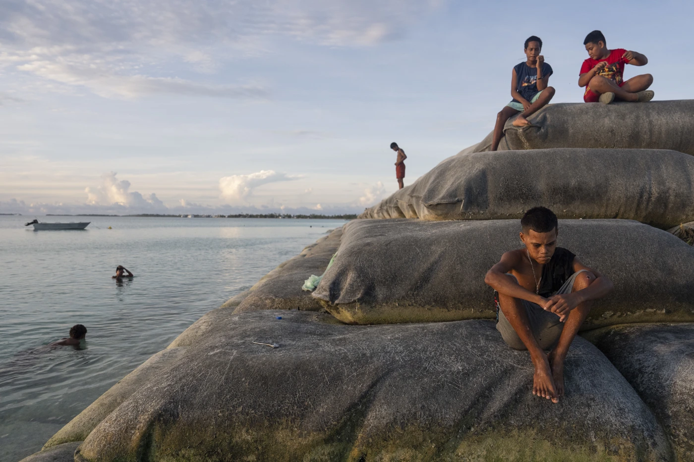 Kinder spielen auf Sandsäcken zur Landgewinnung in Funafuti, Tuvalu, 2. April 2025 – der Inselstaat im Südpazifik kämpft gegen steigende Meeresspiegel und die wirtschaftlichen Folgen der Klimakrise. © Carolyn Van Houten/The Washington Post via Getty Images