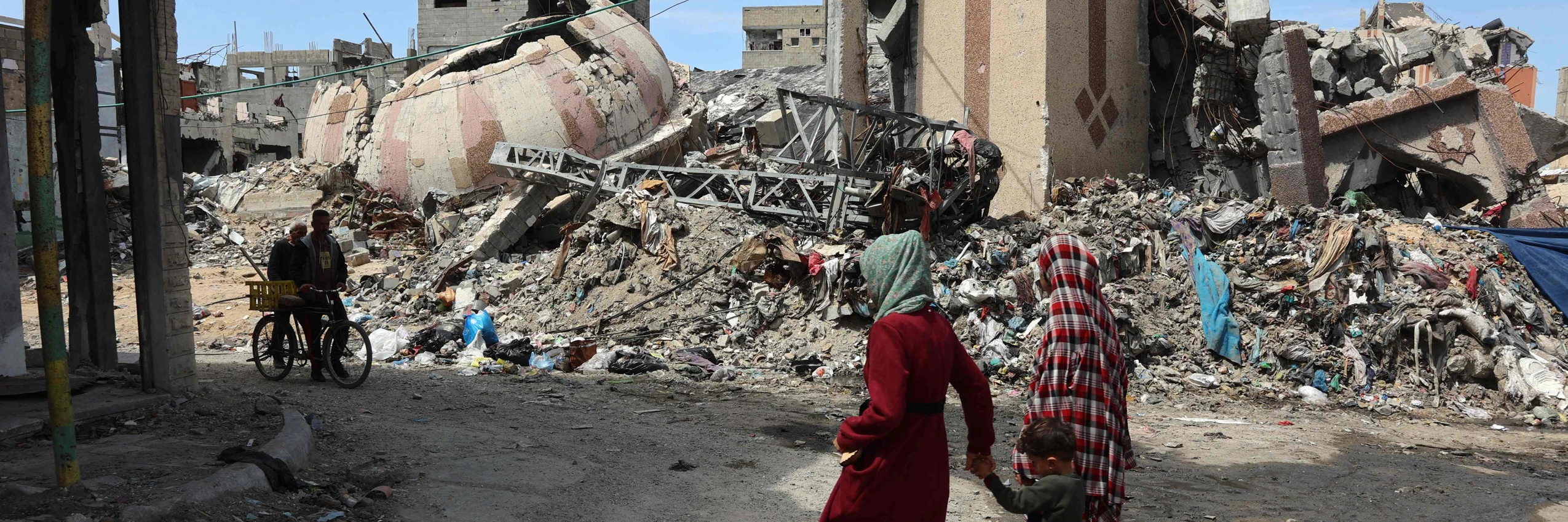 Einwohner*innen gehen am 28. März 2025 in Gaza-Stadt an den Trümmern von Gebäuden vorbei, die während des Krieges zerstört wurden. © OMAR AL-QATTAA / AFP / picturedesk.com