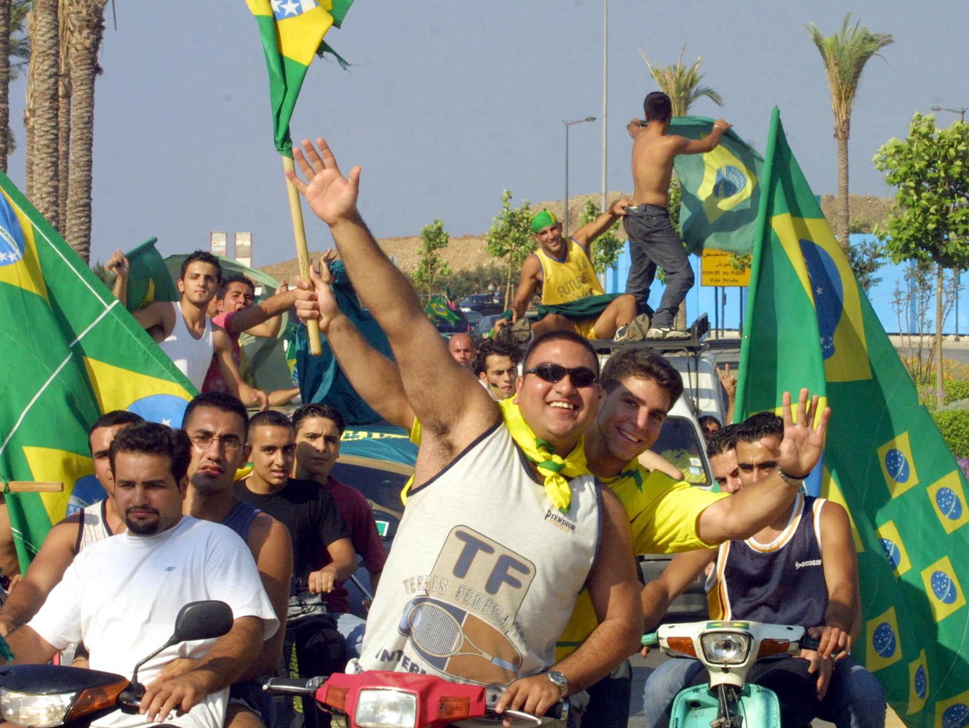 Libanesische Fans der brasilianischen Fußballnationalmannschaft feiern am 30. Juni 2002 in Beirut, nachdem Brasilien Deutschland im WM-Finale in Yokohama mit 2:0 besiegt hat. © JOSEPH BARRAK/AFP via Getty Images