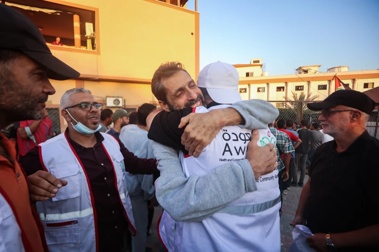Mitarbeiter*innen und Unterstützer*innen empfangen Dr. Ahmad Mhanna nach seiner Freilassung, Khan Yunis, 13. Oktober 2025 @ APA-Images / AFP / OMAR AL-QATTAA
