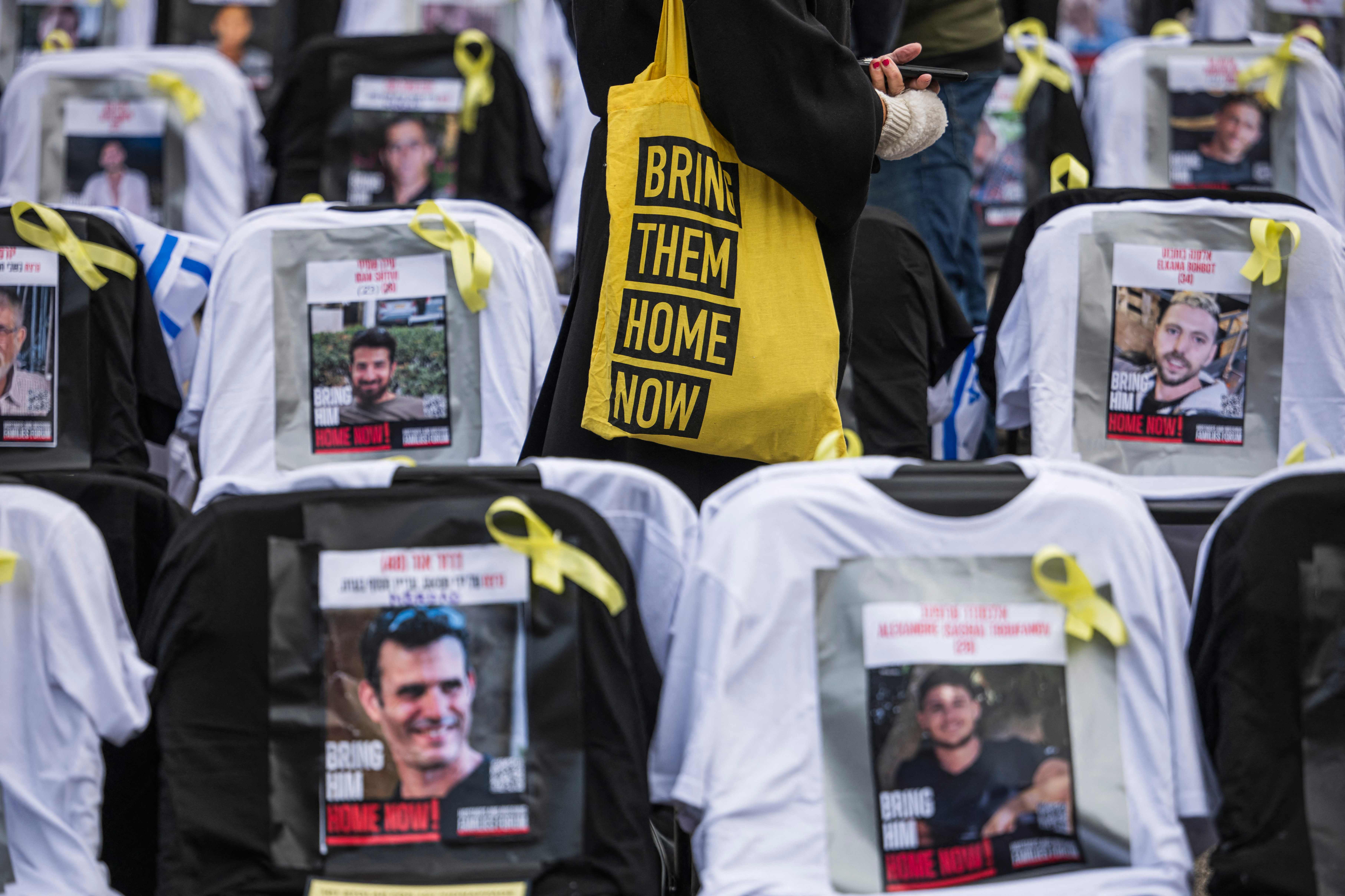 Eine Frau trägt eine Tasche mit der Aufschrift „Bring them home“, bei einer Kunstinstallation für die in Gaza festgehaltenen Geiseln. © Jonathan Nackstrand / APA / picturedesk.com