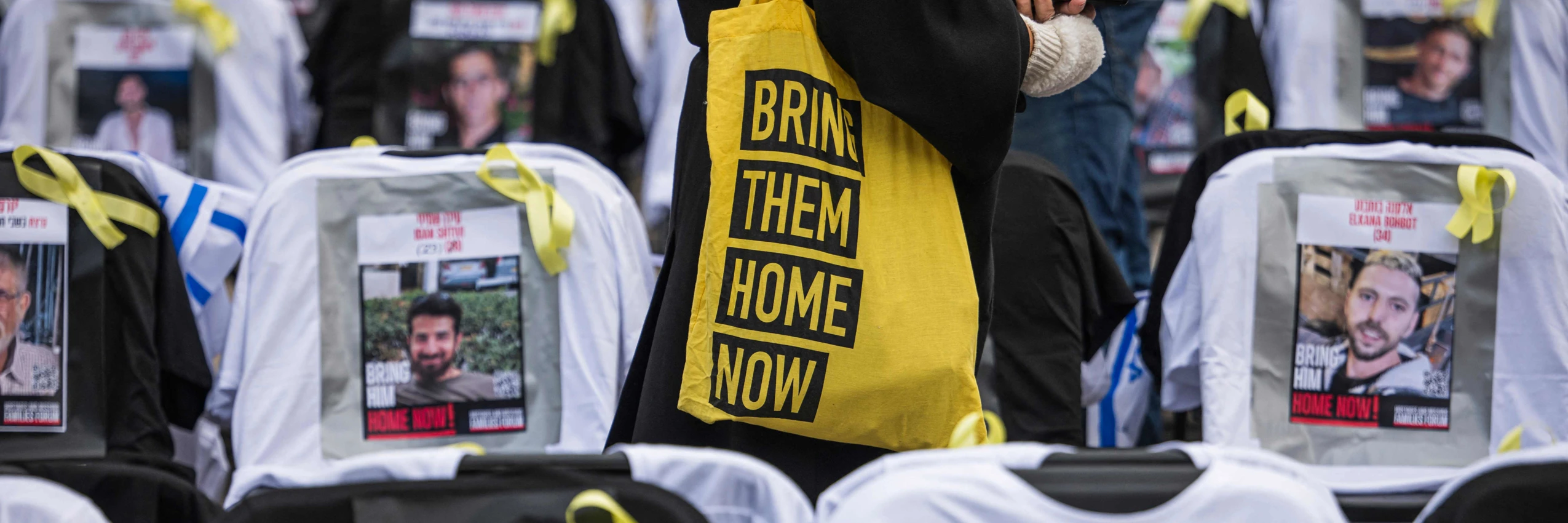 Eine Frau trägt eine Tasche mit der Aufschrift „Bring them home“, bei einer Kunstinstallation für die in Gaza festgehaltenen Geiseln. © Jonathan Nackstrand / APA / picturedesk.com