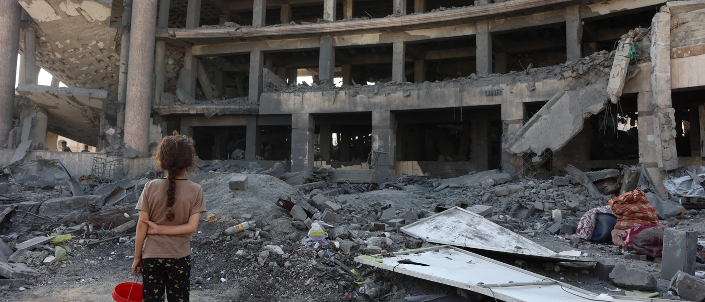 Ein palästinensisches Mädchen steht nach einem nächtlichen Angriff vor dem zerstörten Sheikh-Radwan-Gesundheitszentrum im Norden von Gaza-Stadt, 6. August 2025. © OMAR AL-QATTAA/AFP via Getty Images