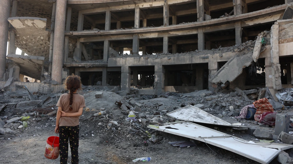 Ein palästinensisches Mädchen steht nach einem nächtlichen Angriff vor dem zerstörten Sheikh-Radwan-Gesundheitszentrum im Norden von Gaza-Stadt, 6. August 2025. © OMAR AL-QATTAA/AFP via Getty Images