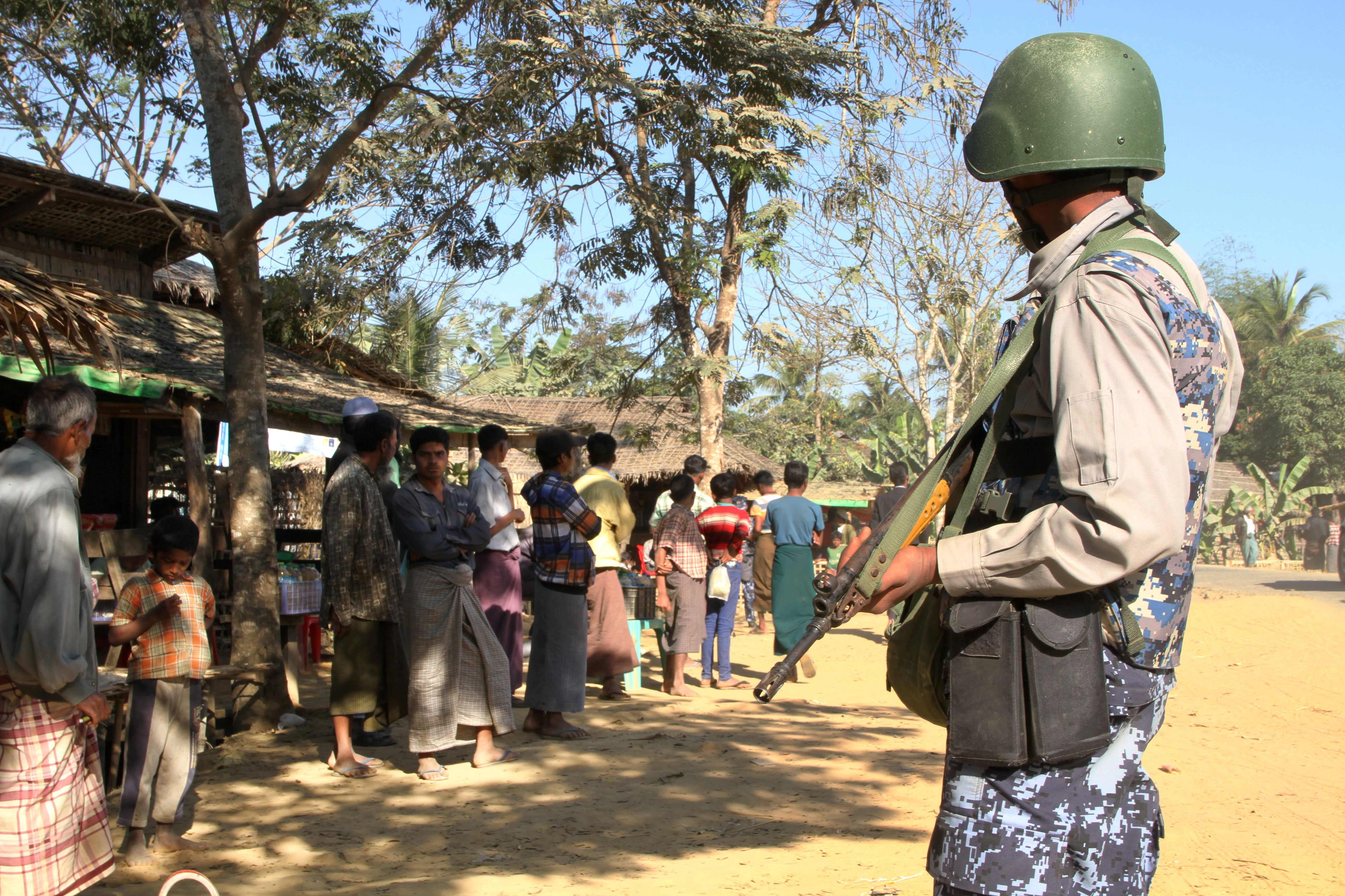 Ein Polizist bewacht eine Gruppe Rohingya im Buthidaung Township © RICHARD SARGENT / AFP / picturedesk.com
