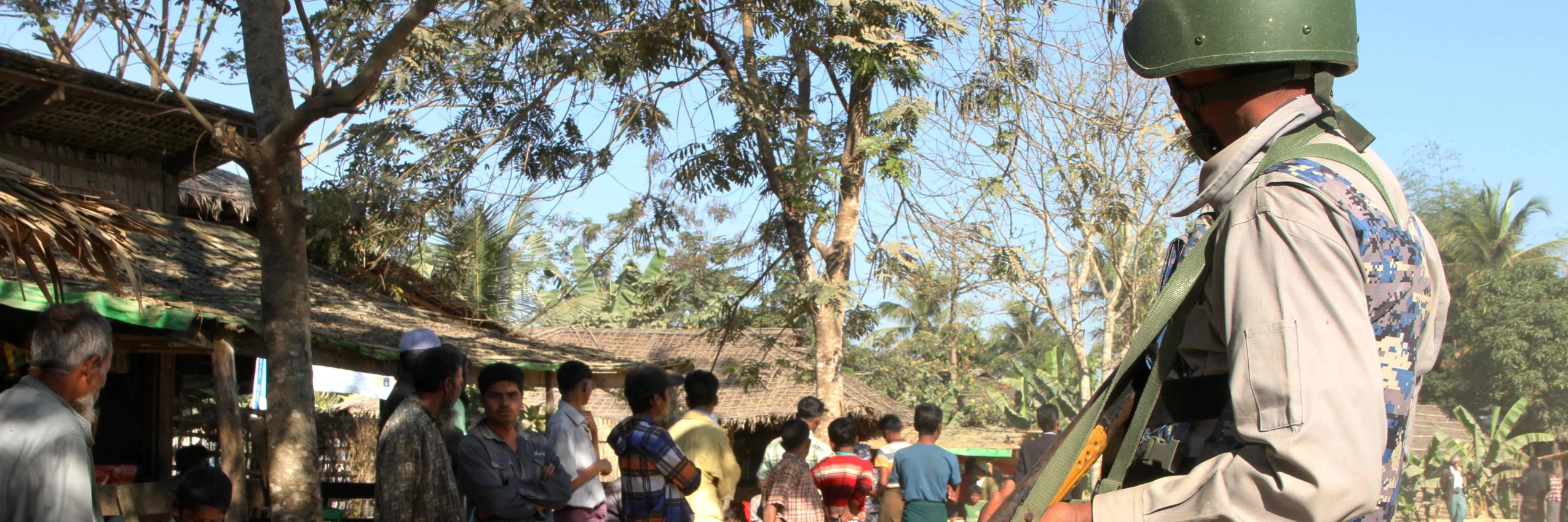Ein Polizist bewacht eine Gruppe Rohingya im Buthidaung Township © RICHARD SARGENT / AFP / picturedesk.com