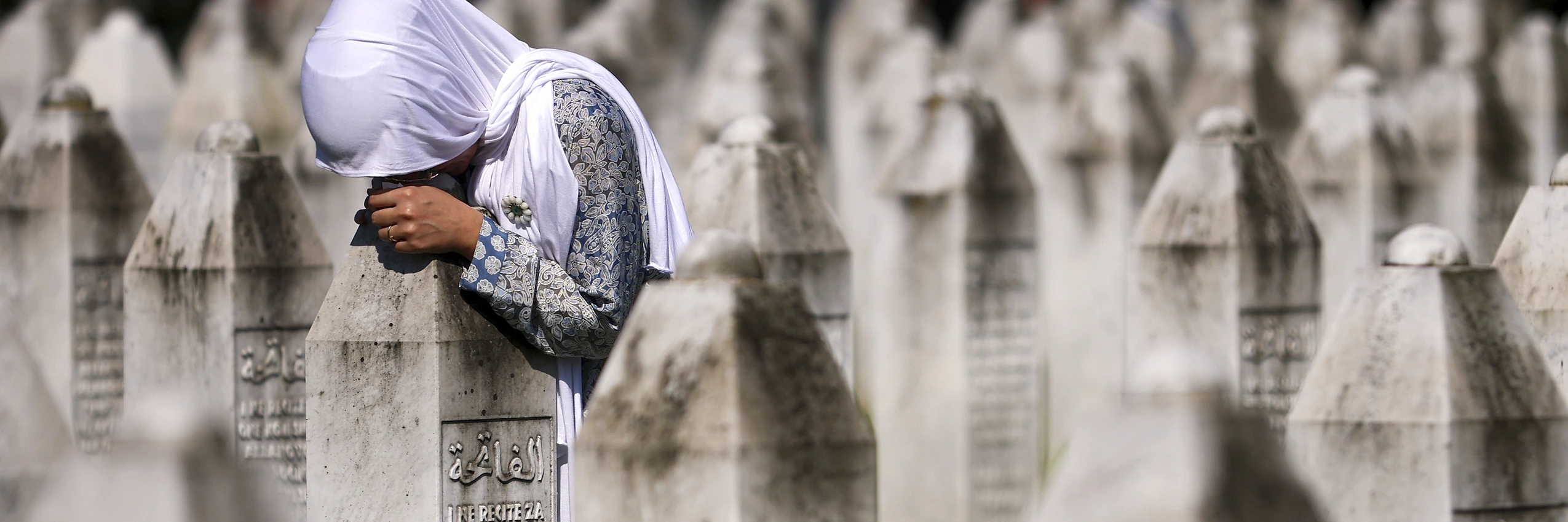 Eine Frau trauert an der Gedenk- und Grabstätte für die Opfer des Völkermords von Srebrenica im bosnischen Dorf Potocari. © Armin Durgut / AP Picturedesk