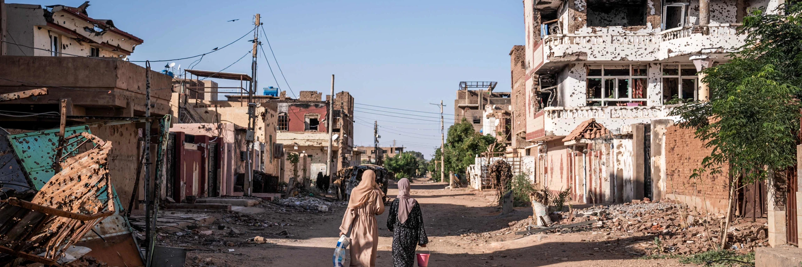 Frauen gehen am 2. November 2024 durch ein vom Krieg zerstörtes Viertel in Omdurman, der zweitgrößten Stadt im Sudan. Der Krieg im Sudan brach im April 2023 zwischen den sudanesischen Streitkräften unter Abdel Fattah al-Burhanund und den paramilitärischen Rapid Support Forces (RSF) unter seinem ehemaligen Stellvertreter Mohamed Hamdan Daglo aus. © Amaury Falt-Brown / AFP / picturedesk.com