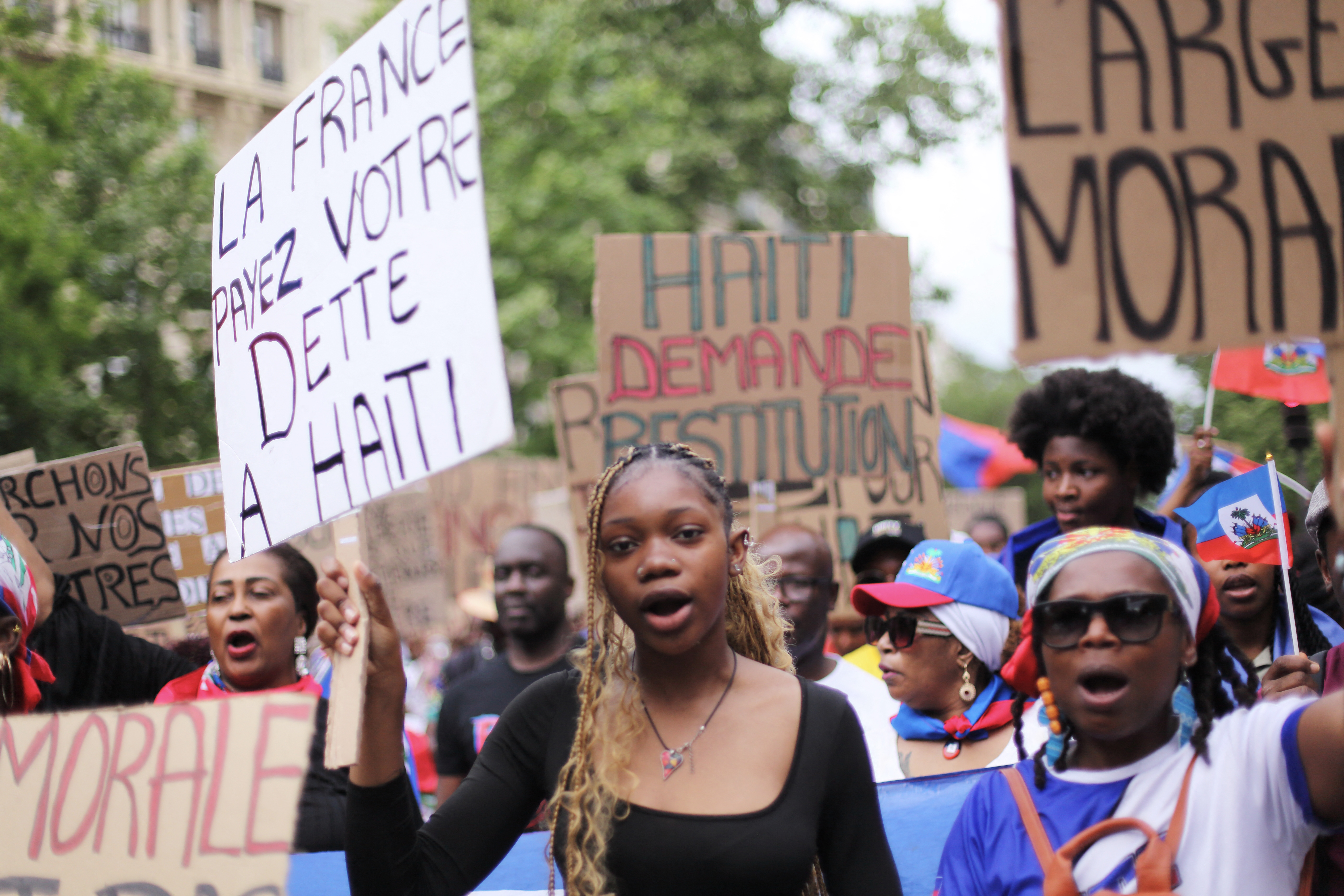 Demonstrant*innen aus der haitianischen Community fordern in Paris Reparationen von Frankreich und Frieden in Haiti, 3. Mai 2025. © Daniel Perron/Hans Lucas/AFP via Getty Images