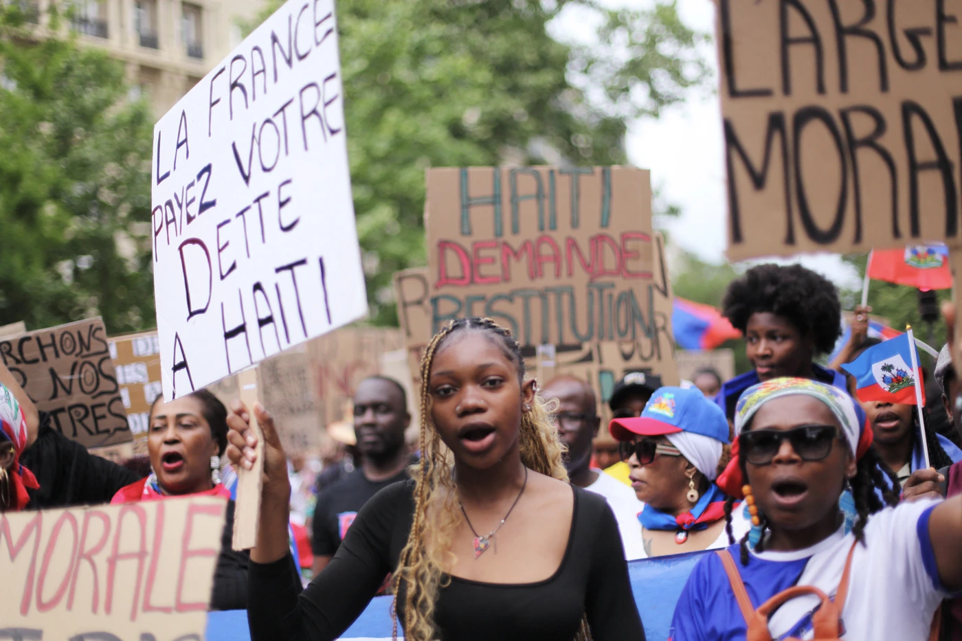 Demonstrant*innen aus der haitianischen Community fordern in Paris Reparationen von Frankreich und Frieden in Haiti, 3. Mai 2025. © Daniel Perron/Hans Lucas/AFP via Getty Images