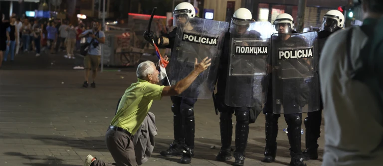 Belgrad, Serbien, 28. Juni 2025: Ein Demonstrant kniet zum Ende des Anti-Korruptionsprotests vor Polizist*innen @ Marko Drobnjakovic AP picturedesk.com