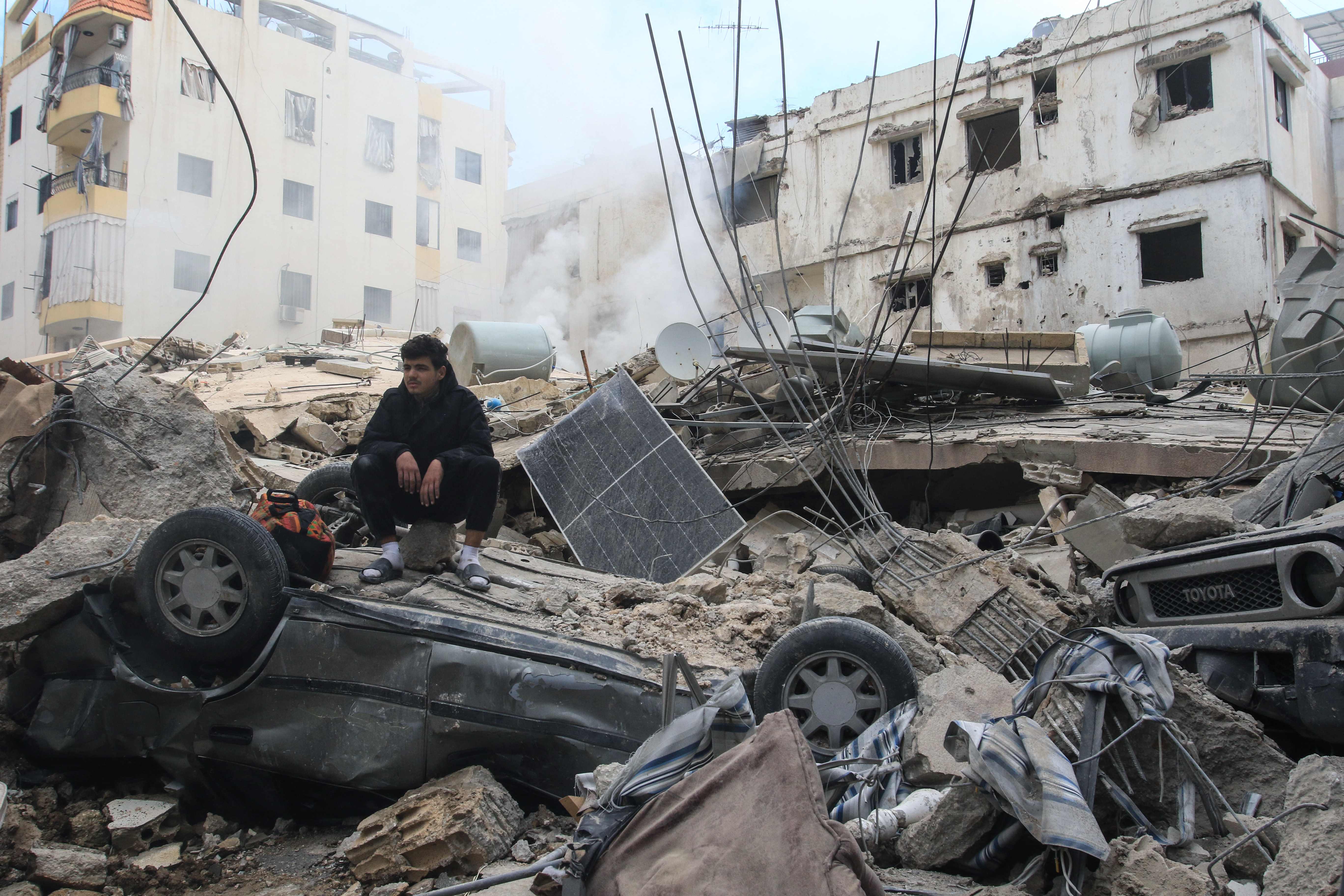 Ein Mann sitzt auf den Trümmern eines Gebäudes in der südlibanesischen Küstenstadt Sidon © APA-Images / AFP / MAHMOUD ZAYYAT