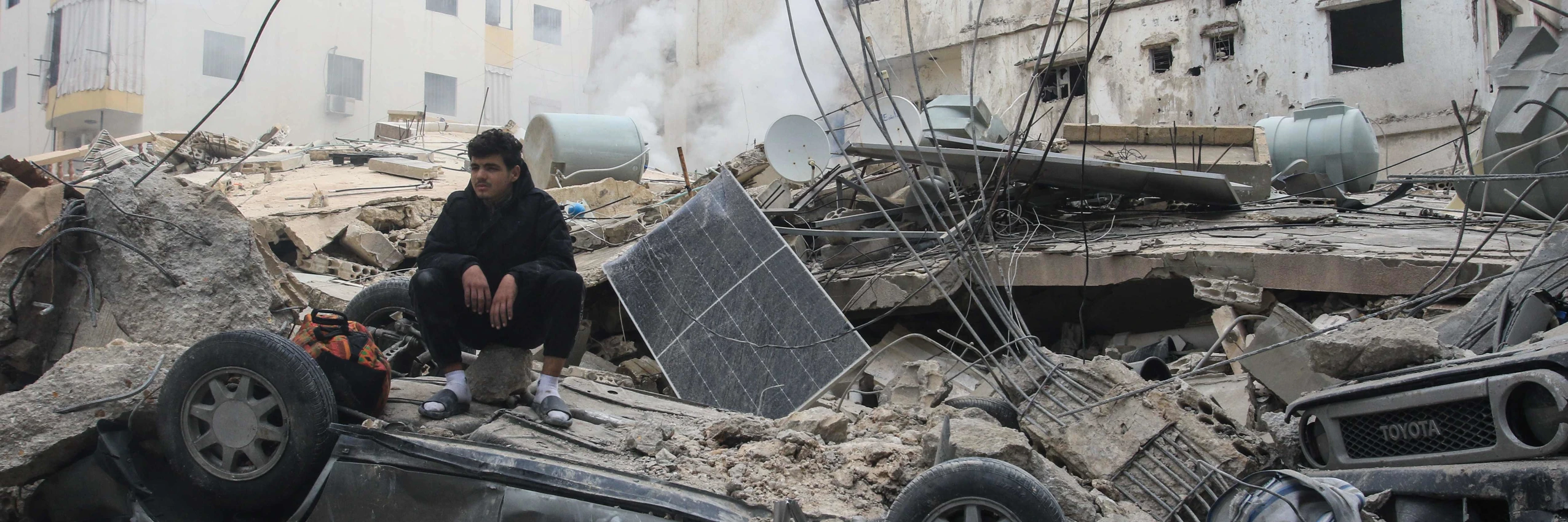 Ein Mann sitzt auf den Trümmern eines Gebäudes in der südlibanesischen Küstenstadt Sidon © APA-Images / AFP / MAHMOUD ZAYYAT