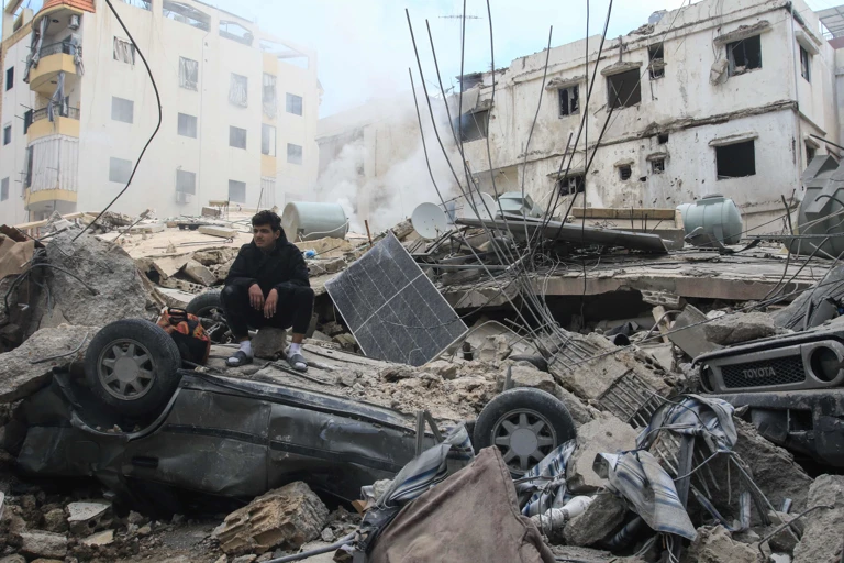 Ein Mann sitzt auf den Trümmern eines Gebäudes in der südlibanesischen Küstenstadt Sidon @ APA-Images / AFP / MAHMOUD ZAYYAT