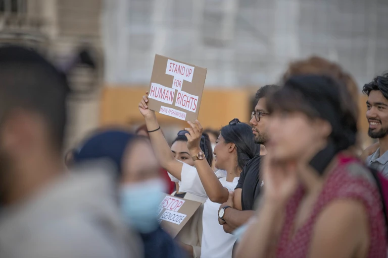 Eine Teilnehmerin hält auf einer Demo ein Schild mit der Aufschrift "Stand up for human rights" im Jahr 2021. @ Tobias Steinmaurer / picturedesk.com 