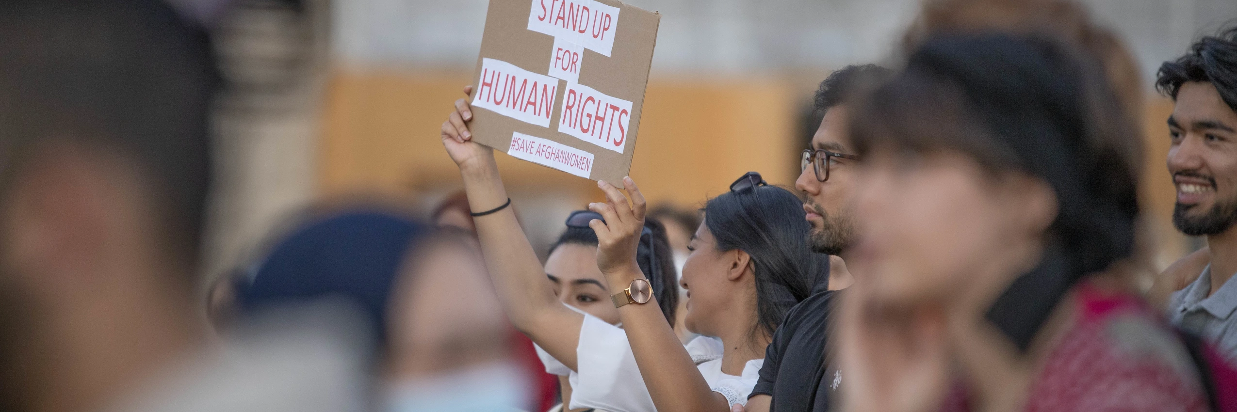 Eine Teilnehmerin hält auf einer Demo ein Schild mit der Aufschrift "Stand up for human rights" im Jahr 2021. © Tobias Steinmaurer / picturedesk.com