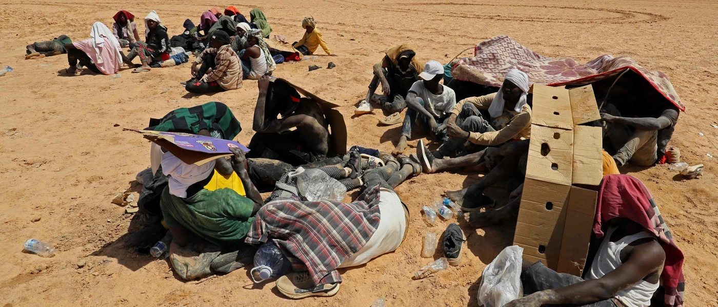 Migranten, die behaupten, von den tunesischen Behörden ohne Wasser und Unterkunft in der Wüste ausgesetzt worden zu sein, Juli 2023 nahe der libyschen Grenzstadt Al-Assah. © MAHMUD TURKIA / AFP / picturedesk.com