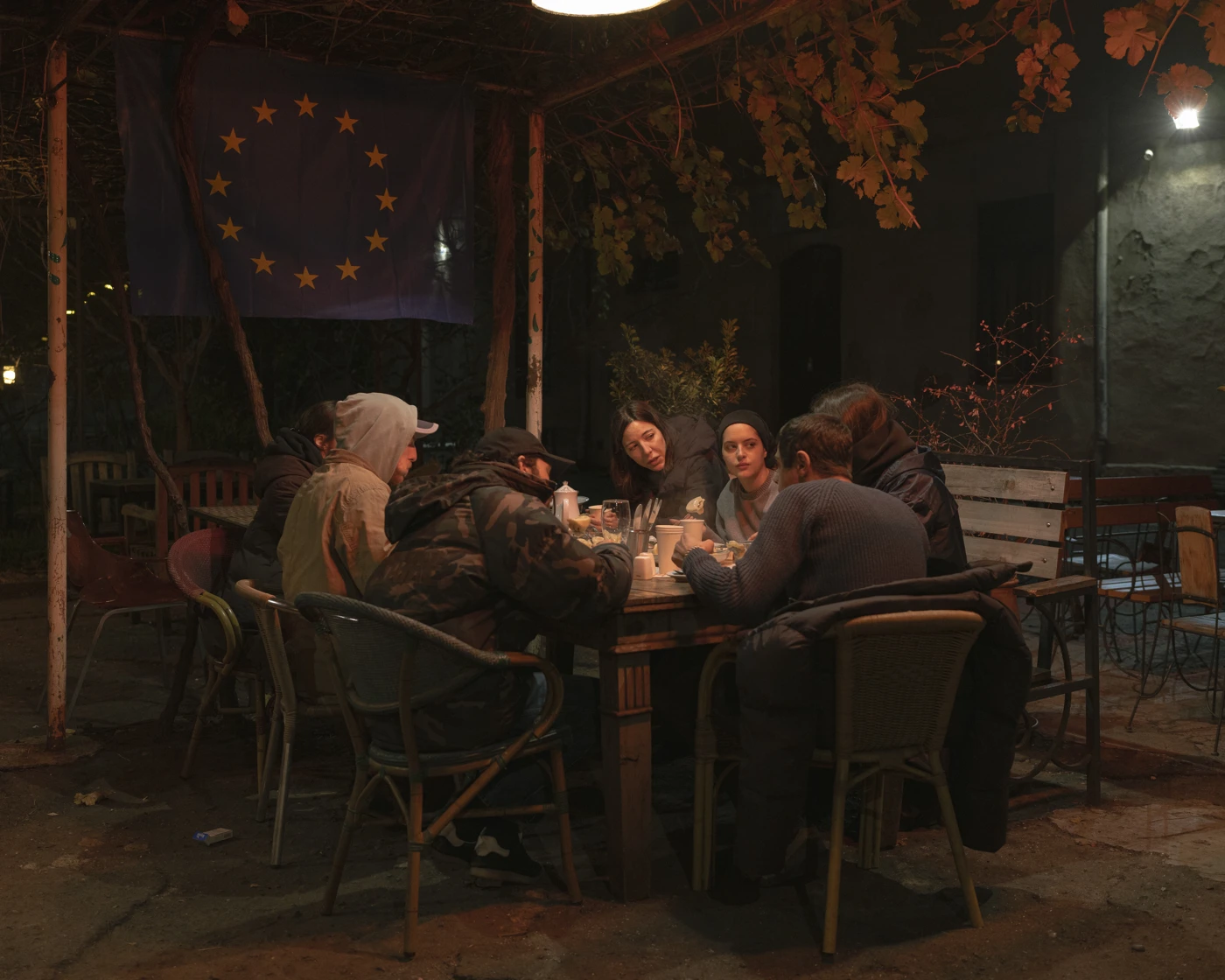 In der Innenstadt von Tbilisi solidarisieren sich viele Restaurants und kulturelle Institutionen mit den Protesten. Eine Gruppe junger Menschen isst in einem Café zu Abend, oder wie sie selbst sagen: “Wir stärken uns, bevor wir wieder Protestieren gehen.” © Sitara Thalia Ambrosio/laif/picturedesk.com