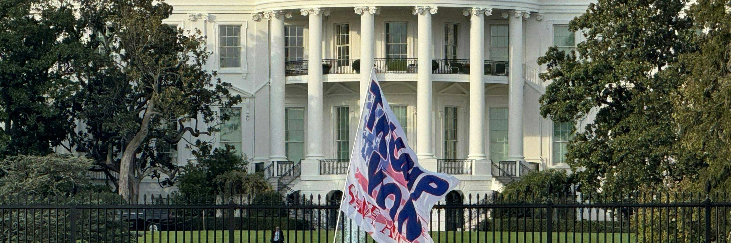 Ein Anhänger von Donald Trump schwenkt am 6. November 2024 eine riesige Flagge vor dem Weißen Haus in Washington, DC, USA. © DANIEL SLIM / AFP / picturedesk.com