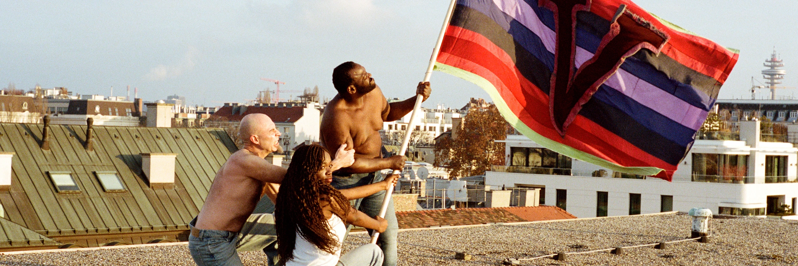 Das Bild zeigt die diesjährige Fahne der Freien Republik Wien, die im Rahmen der Wiener Festwochen gehisst wird. Sie weht auf dem Dach des ehemaligen Funkhauses in der Wiener Argentinierstraße, dem zentralen Ort und Club des diesjährigen Festivals, das die revolutionäre Kraft der Liebe feiert. © Anna Breit