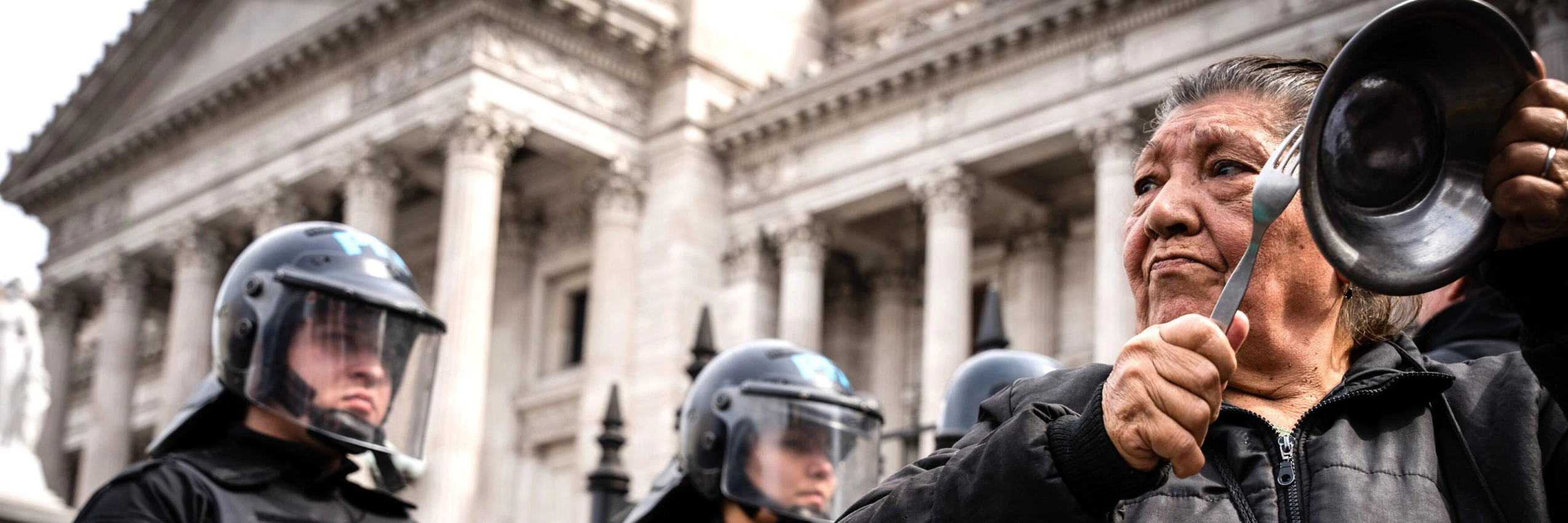 Eine Pensionistin schlägt mit einem Löffel auf eine Pfanne bei einem Protest gegen das geplante Pensionsgesetz © Getty