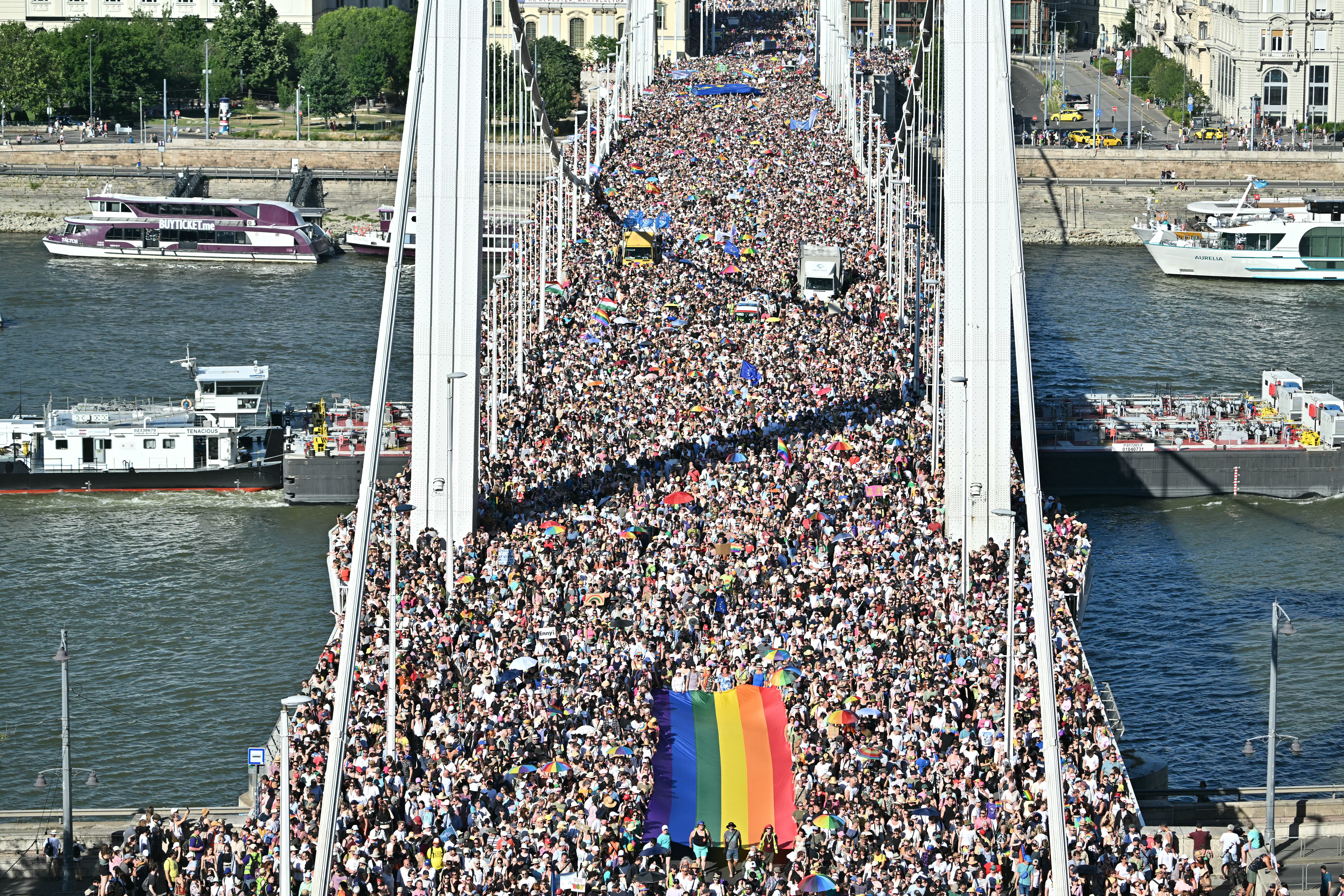 Teilnehmende tragen eine Regenbogenflagge bei der von der Orban-Regierung verbotenen Budapester Pride,  28. Juni 2025. Über 300.000 Menschen widersetzten sich dem Verbot. © ATTILA KISBENEDEK/AFP via Getty Images