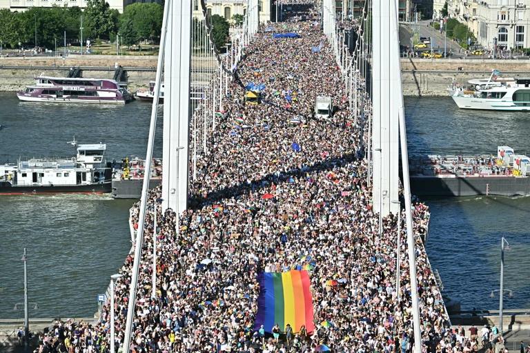 Teilnehmende tragen eine Regenbogenflagge bei der von der Orban-Regierung verbotenen Budapester Pride,  28. Juni 2025. Über 300.000 Menschen widersetzten sich dem Verbot. @ ATTILA KISBENEDEK/AFP via Getty Images