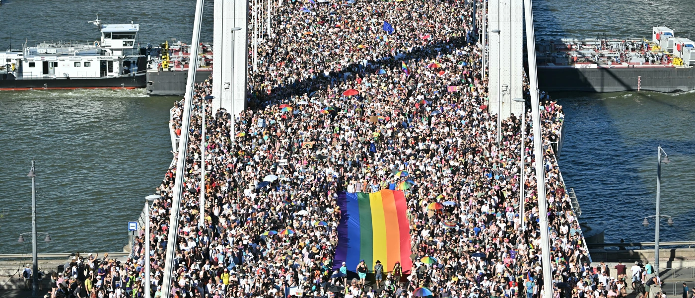 Teilnehmende tragen eine Regenbogenflagge bei der von der Orban-Regierung verbotenen Budapester Pride, 28. Juni 2025. Über 300.000 Menschen widersetzten sich dem Verbot. © ATTILA KISBENEDEK/AFP via Getty Images