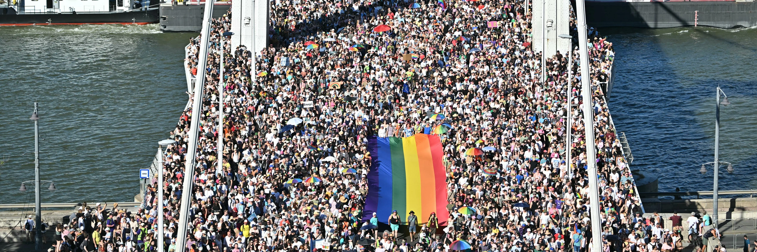 Teilnehmende tragen eine Regenbogenflagge bei der von der Orban-Regierung verbotenen Budapester Pride, 28. Juni 2025. Über 300.000 Menschen widersetzten sich dem Verbot. © ATTILA KISBENEDEK/AFP via Getty Images