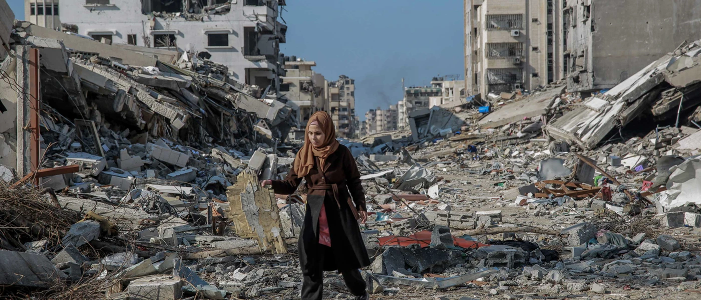 Eine Frau in den Trümmern zerstörter Häuser nach israelischen Luftangriffen auf Gaza. © Omar El Qattaa / Amnesty International
