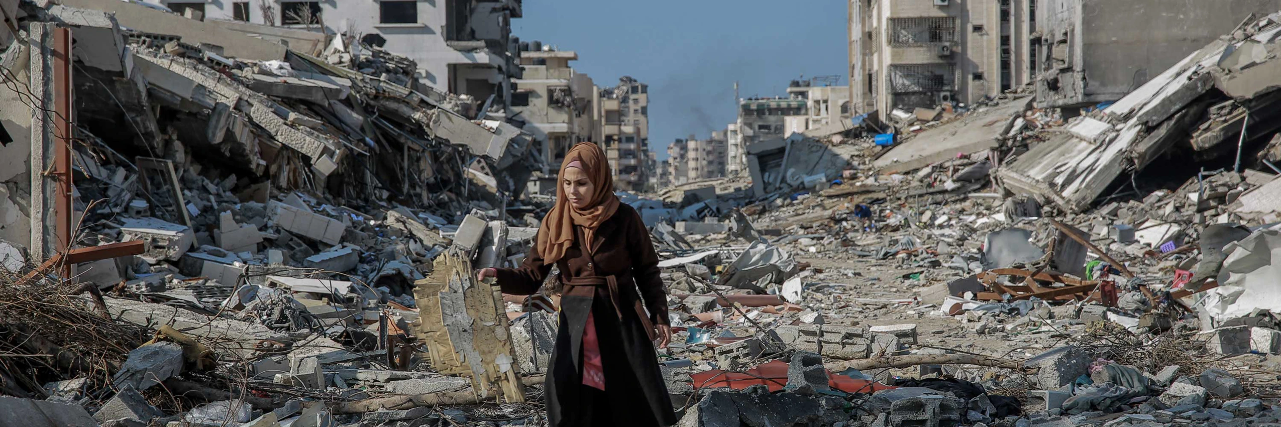 Eine Frau in den Trümmern zerstörter Häuser nach israelischen Luftangriffen auf Gaza. © Omar El Qattaa / Amnesty International