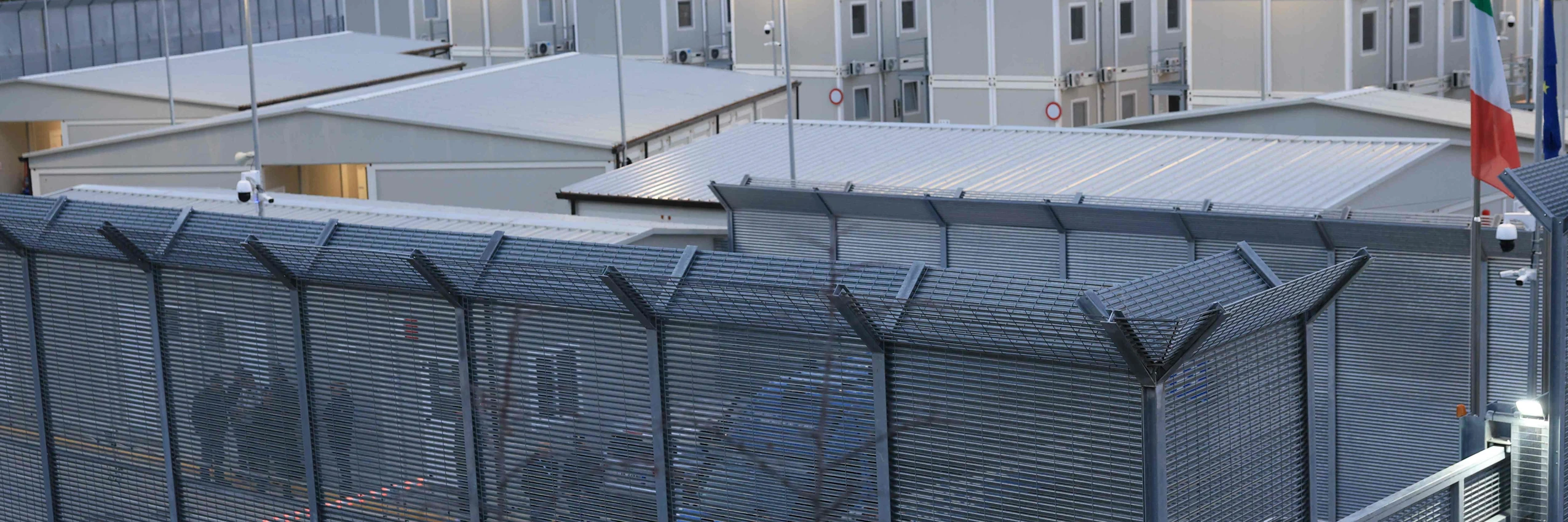 Polizist*innen sichern den Eingang eines italienisch geführten Abschiebezentrums im albanischen Gjader. © APA-Images / AFP / ADNAN BECI