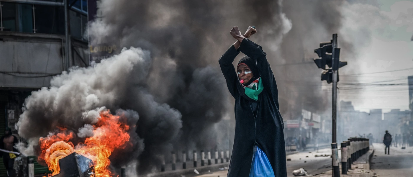Eine Demonstrantin vor einer brennenden Barrikade, Nairobi, Kenia, 25. Juni 2025. Bei Protesten ein Jahr zuvor waren mindestens 60 Menschen von den Behörden getötet worden, Aufarbeitung fehlt. © Luis Tato / AFP via Getty Images