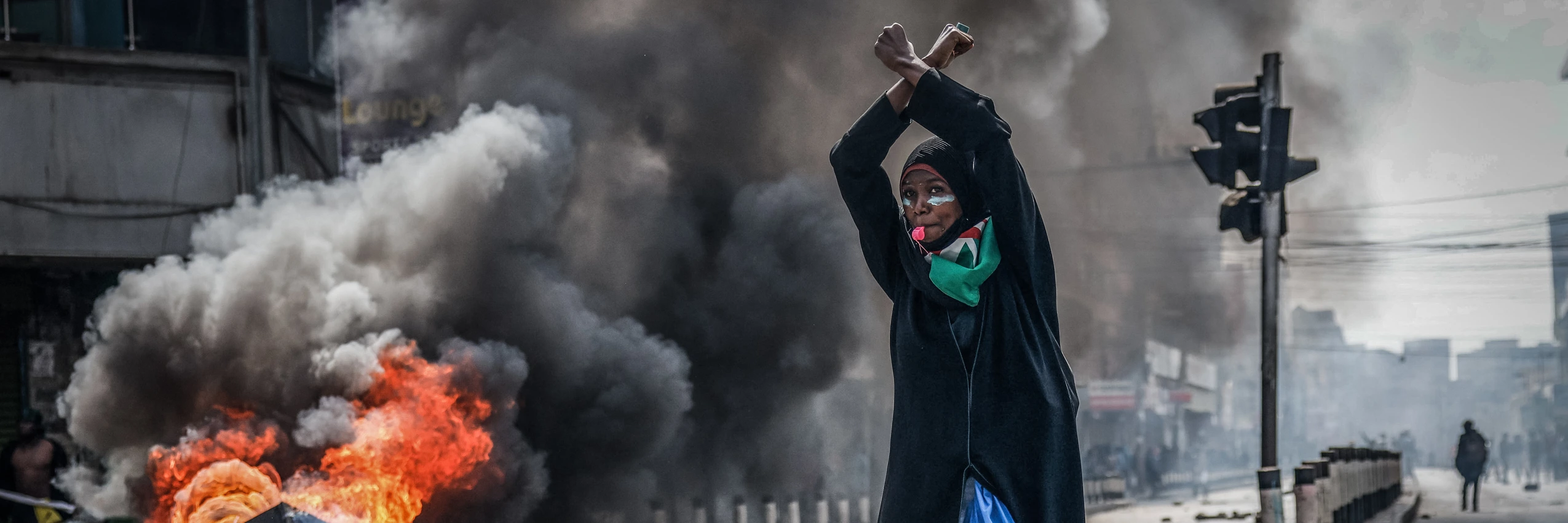 Eine Demonstrantin vor einer brennenden Barrikade, Nairobi, Kenia, 25. Juni 2025. Bei Protesten ein Jahr zuvor waren mindestens 60 Menschen von den Behörden getötet worden, Aufarbeitung fehlt. © Luis Tato / AFP via Getty Images