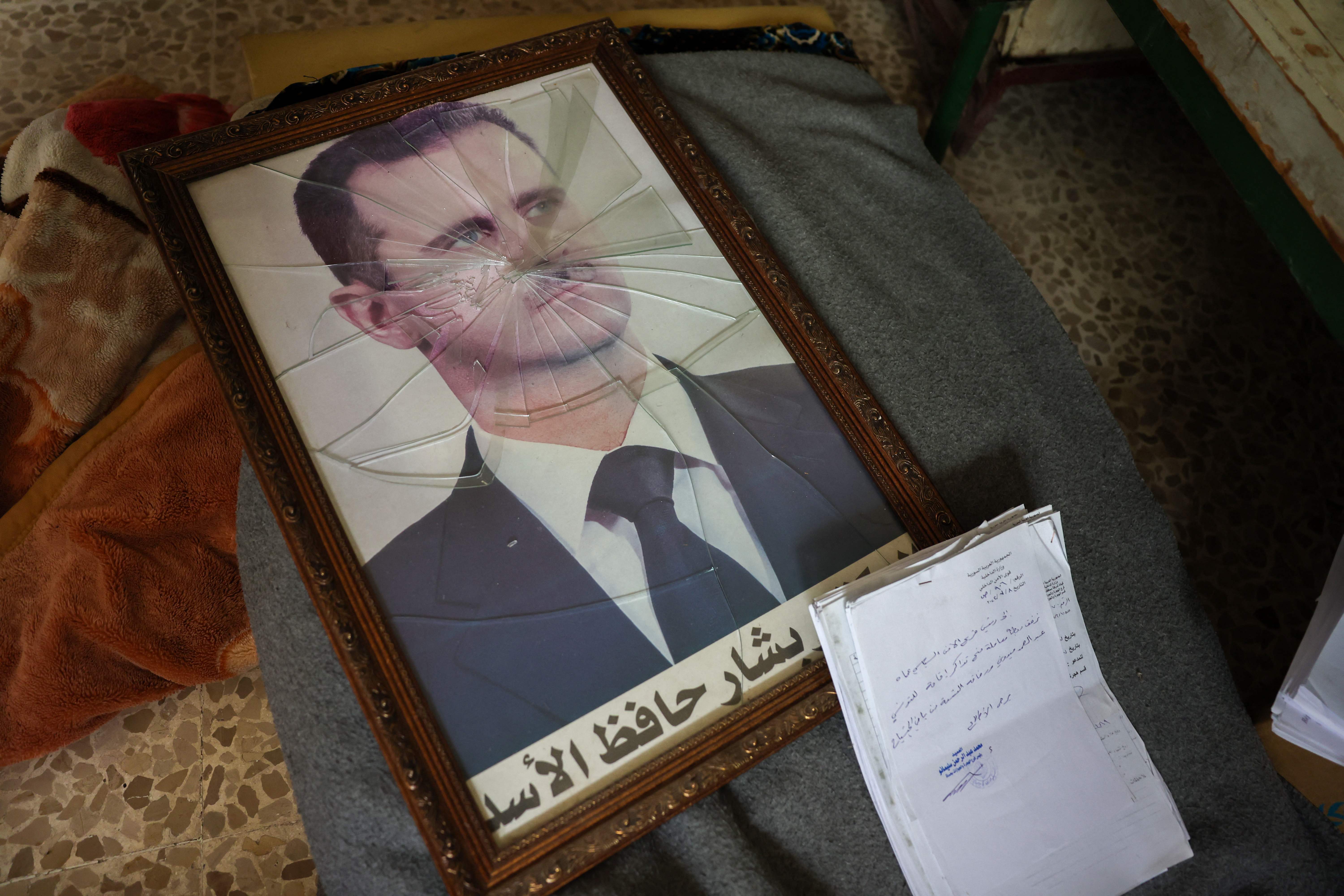 Ein Portrait des gestürzten syrischen Machthabers Bashar al-Assad hinter zerbrochenem Glas © Omar Haj Kadour / APA-Images