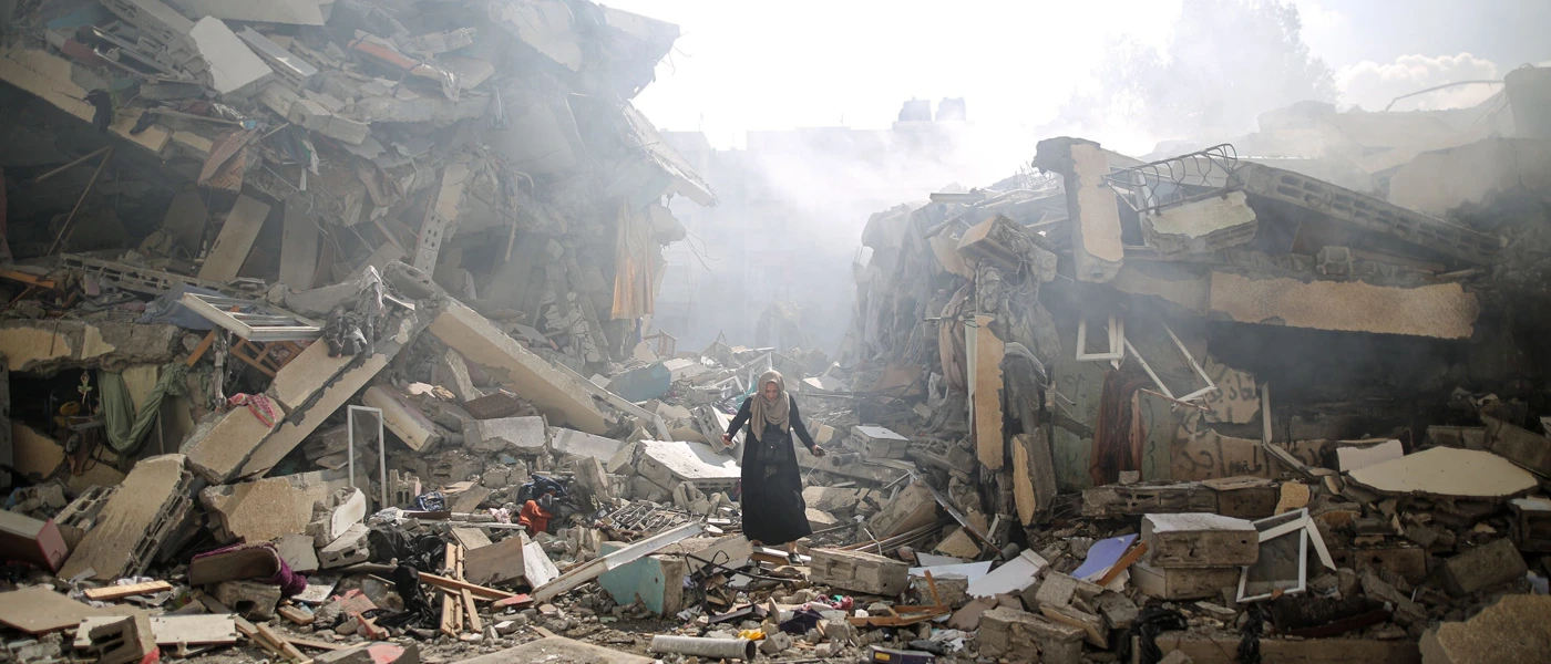 Eine Frau in den Trümmern zerstörter Gebäude nach israelischen Luftangriffen, Gaza, Oktober 2023. © Mustafa Hassona Anadolu Via Getty Images