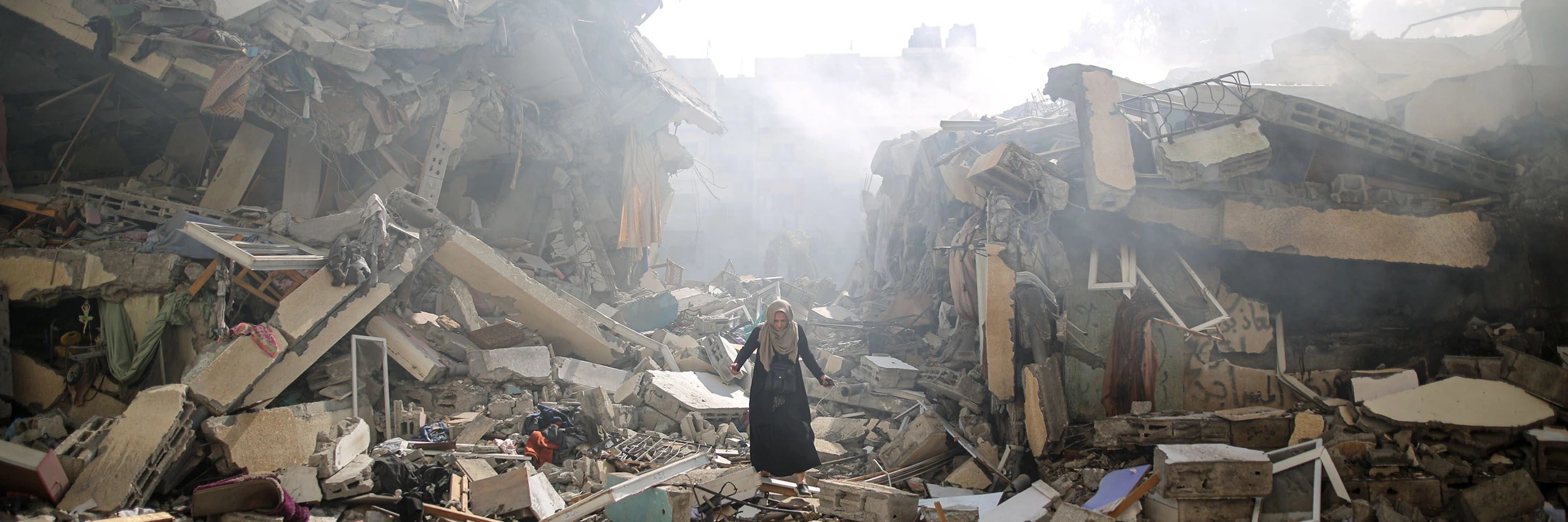 Eine Frau in den Trümmern zerstörter Gebäude nach israelischen Luftangriffen, Gaza, Oktober 2023. © Mustafa Hassona Anadolu Via Getty Images
