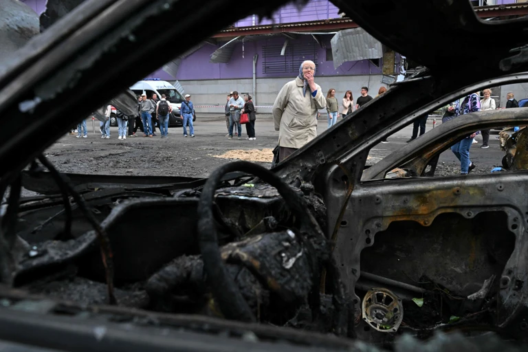 Eine Frau betrachtet die verbrannten Autos nach einem nächtlichen Drohnenangriff auf Kiew vor einem Einkaufszentrum @ SERGEI SUPINSKY / AFP / picturedesk.com