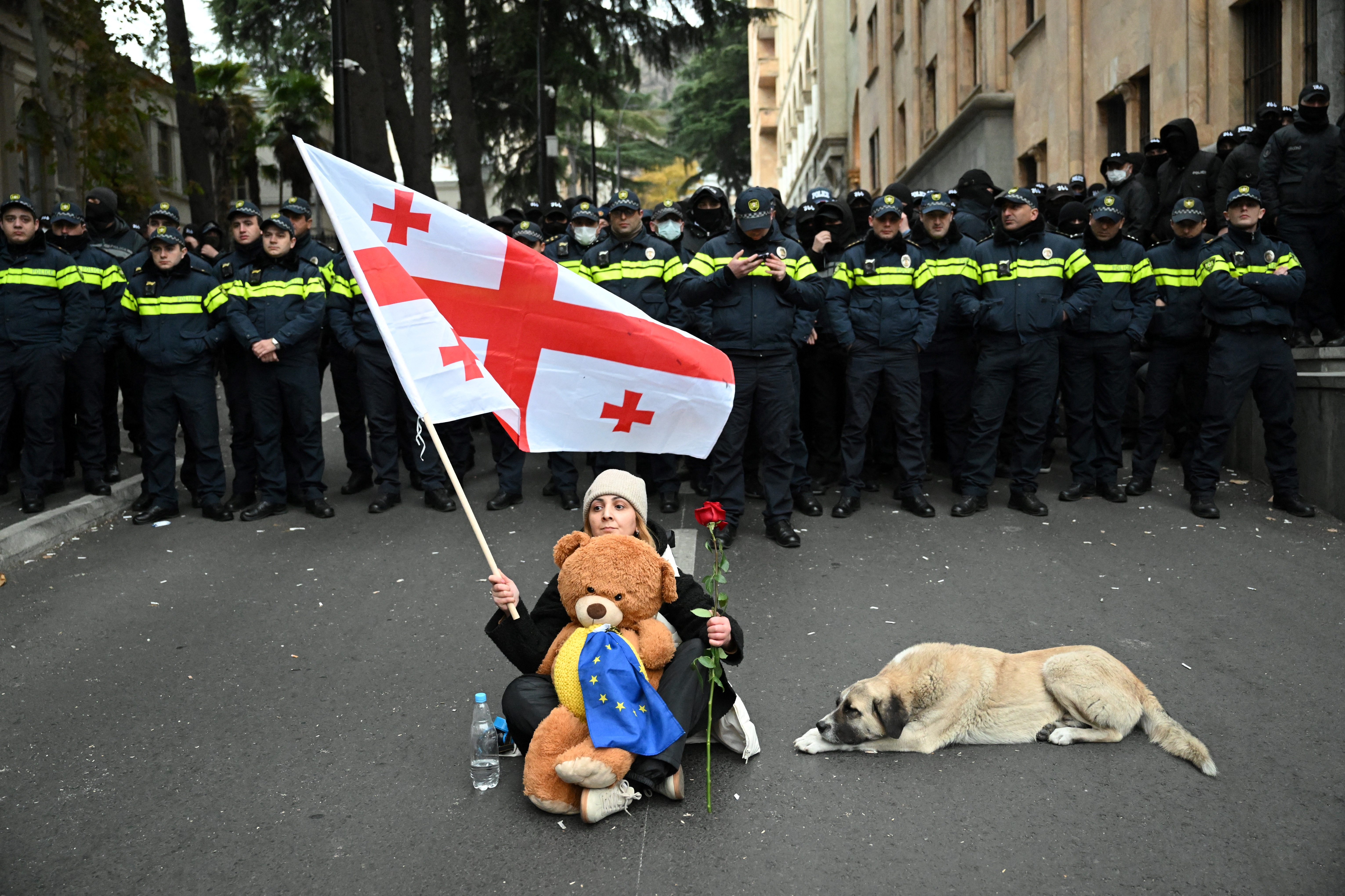 Georgien: Eine Frau hält bei einem Protest gegen die Ergebnisse der Parlamentswahlen eine rote Rose und eine georgische Flagge in die Höhe. © Vano Shlamov/AFP via Getty Images
